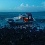 Kara parçasında kalan teknedekiler çaresiz kaldı